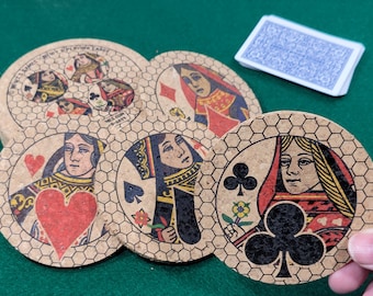 May include: Six cork coasters with a hexagonal pattern and images of playing card queens. Each coaster features a different queen with a different suit: hearts, diamonds, clubs, and spades. The coasters are made of cork and have a natural brown color.