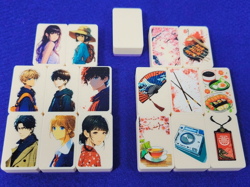 May include: A set of 12 double-sided dominoes with various images, including anime characters, Japanese-inspired designs, and food. The dominoes are white with rounded edges.