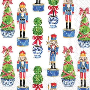 May include: A white background with a repeating pattern of nutcracker soldiers, Christmas trees, and topiary trees. The nutcracker soldiers are wearing red and blue uniforms with gold accents. The Christmas trees are decorated with red ribbons and green and red ornaments. The topiary trees are in blue and white pots.