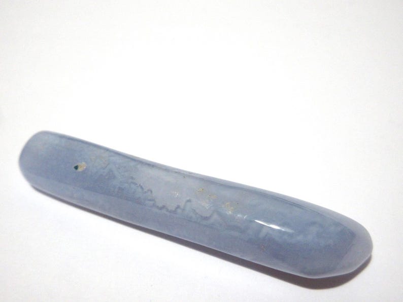 May include: A smooth, elongated, light blue stone with a rounded shape. The stone has subtle variations in color and texture, and appears to be polished. The object is set against a white background.