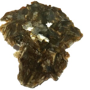 Può includere: Primo piano di un pezzo di mica, un minerale con una struttura a strati. La mica è un mix di colori marrone, oro e trasparenti, con un aspetto leggermente traslucido. Il minerale è su sfondo bianco.