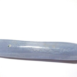May include: A smooth, elongated, blue-gray stone with a rounded shape. The stone has subtle variations in color and texture, and appears to be polished. The object is set against a plain white background.