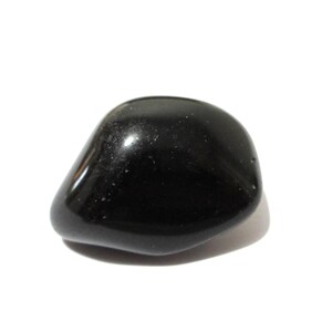 Op de afbeelding: Een gepolijste, gladde, zwarte edelsteen, mogelijk obsidiaan of onyx, op een witte achtergrond. De steen heeft een afgeronde vorm en een glanzend oppervlak dat licht reflecteert. Het lijkt een natuurlijke getrommelde steen te zijn.