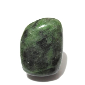 Puede incluir: Una piedra preciosa pulida, de forma ovalada, con un patrón moteado de verde oscuro y negro. La piedra tiene una superficie lisa y redondeada y un aspecto natural. La piedra preciosa está sobre un fondo blanco.