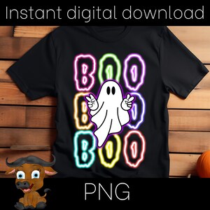 May include: Black t-shirt with a neon-style design featuring the word "BOO" three times, with a ghost in the center. The ghost is white and making a peace sign. A small pumpkin and a cartoon buffalo are in the image.