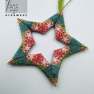 Peut inclure: Une décoration de Noël en forme d'étoile, faite de perles, avec un motif à carreaux vert, or, rose et blanc. La décoration est suspendue à un ruban vert.