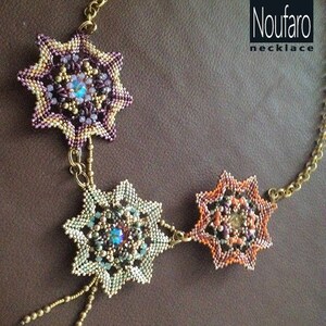May include: A gold chain necklace with three star-shaped pendants. The pendants are made of beads in shades of purple, green, and orange. The necklace is labeled "Noufaro necklace".