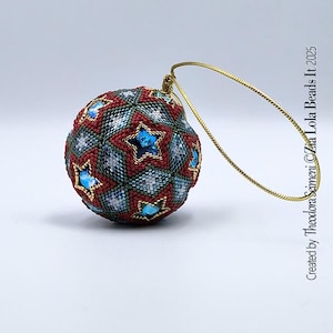 Könnte beinhalten: Ein mit Perlen besetzter Weihnachtsschmuck mit einer goldenen Aufhängeschlaufe. Der kugelförmige Schmuck ist mit roten, grünen und blauen Perlen bedeckt. Blaue sternförmige Akzente sind gleichmäßig auf der Oberfläche verteilt. Text: "Created by Theodora Seimeni ©Zia Lola Beads It 2025."