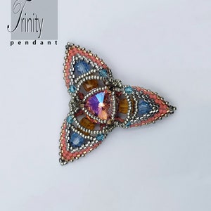 May include: A beaded pendant with a triangular shape, featuring a central iridescent crystal surrounded by layers of silver, orange, blue, and pink beads. The pendant is labeled "Trinity pendant".