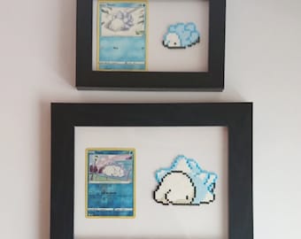 Puede incluir: Dos marcos de fotos negros con paspartús blancos. El marco superior contiene una carta de Pokemon con Snorlax y un Snorlax de pixel art. El marco inferior contiene una carta de Pokemon con Snorlax y un Snorlax de pixel art.