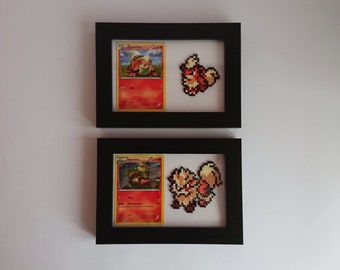 Puede incluir: Dos marcos de fotos negros con paspartús blancos. Cada marco contiene una carta de Pokemon y una versión de pixel art del Pokemon. El marco superior presenta una carta de Growlithe y un Growlithe de pixel art. El marco inferior presenta una carta de Arcanine y un Arcanine de pixel art.