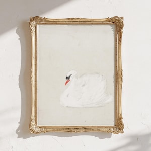 Vintage swan painting in an ornate gold frame, showing a softly painted white swan with a black face and orange beak against a pale neutral background, with sunlight and shadows falling across the wall.