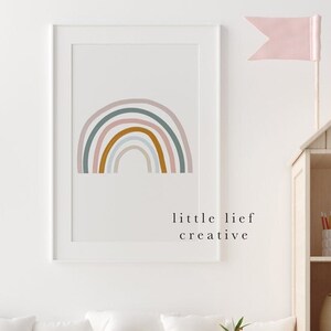 May include: A framed print of a rainbow with pastel colours, including pink, blue, green, and orange. The print has the text "little lief creative" at the bottom.