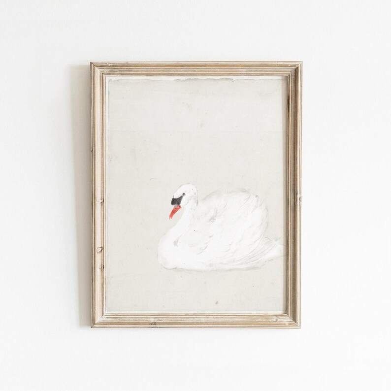 Vintage swan painting in a distressed pale wood frame, featuring a softly painted white swan with a black face and bright orange beak resting against a lightly textured cream background.