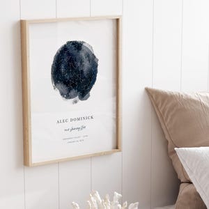 Custom star map print showing the night sky and constellations, personalized with a name and birth details, framed in a modern transitional bedroom.