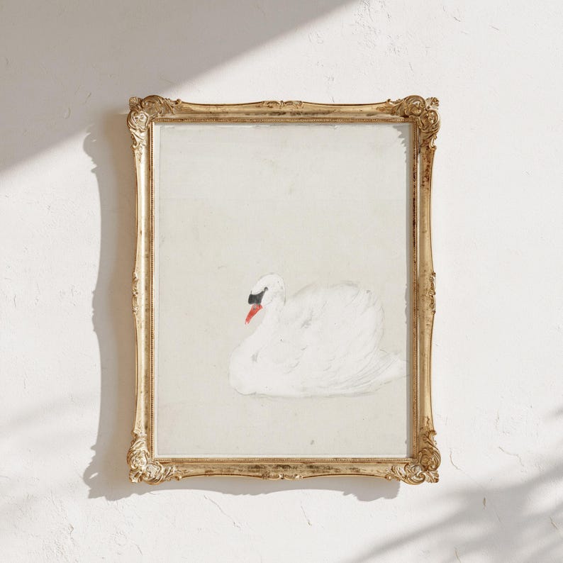 Vintage swan painting in an ornate gold frame, showing a softly painted white swan with a black face and orange beak against a pale neutral background, with sunlight and shadows falling across the wall.