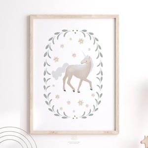 Neutral unicorn print framed in light wood and hung on a white wall with soft shadowing, in a kids playroom.