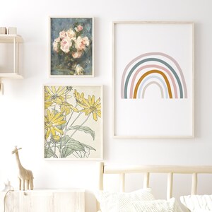 May include: Three framed prints with a white background. The top print features a watercolour painting of pink roses in a vase. The middle print features a watercolour painting of yellow flowers. The bottom print features a rainbow with a light pink, light blue, and orange colour scheme.
