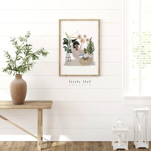 K&ouml;nnte beinhalten: Eine gerahmte Illustration einer Person, die sich in einer H&auml;ngematte entspannt, umgeben von Pflanzen und Sonnenblumen. Der Text "little lief creative" ist unter dem Bild gedruckt.
