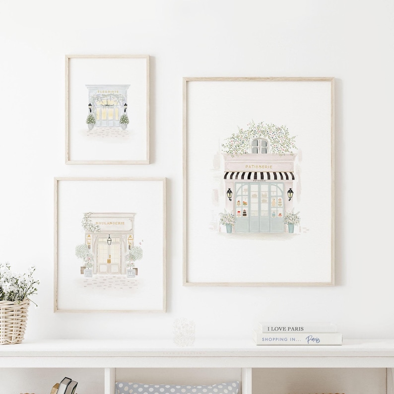 Set of three watercolor paintings of Parisian shops: a Florist, a Boulangerie, and a Patisserie. Each features charming storefront details, potted plants, and inviting atmospheres. Perfect for adding a touch of French elegance to any space.