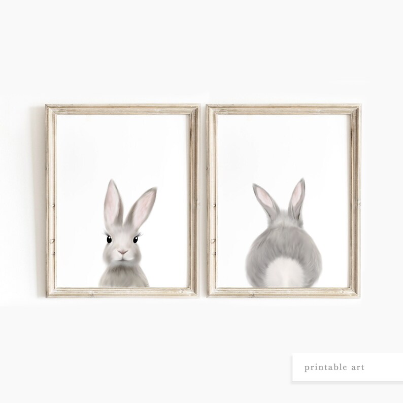 May include: A set of two printable art prints featuring a gray bunny rabbit. The first print shows the bunny facing forward, while the second print shows the bunny from behind. Both prints are framed in a light wood frame.
