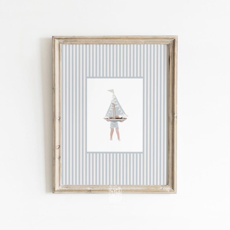 Striped nautical sailboat artwork in a distressed white frame, styled on a bright white wall for vintage-inspired kids or bathroom decor.