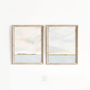 Minimalist beach-inspired wall art duo displayed in a bright, airy space with natural wood tones and soft linen textures.