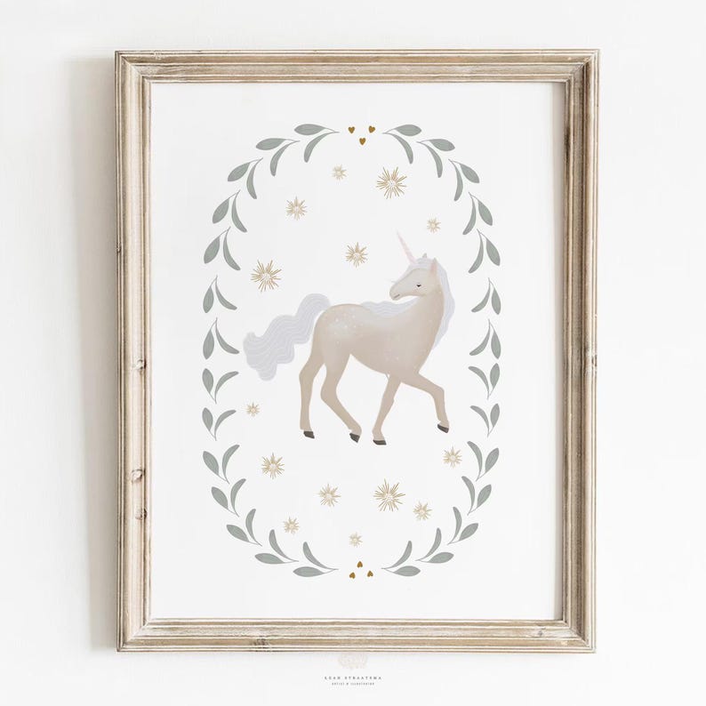 Framed unicorn wall art with neutral tones, displayed on a plain white wall in a light wood frame.