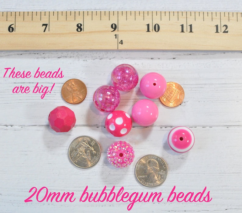 May include: A collection of pink bubblegum beads, approximately 20mm in size, with various textures and designs, including polka dots and glitter. The text "These beads are big!" and "20mm bubblegum beads" is visible.