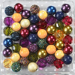 May include: A collection of colorful beads in various shapes and sizes, including round, faceted, and textured beads. The beads are arranged in a clear square container with a white polka dot pattern.