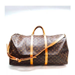 May include: A brown and tan Louis Vuitton Keepall 55 travel bag with a monogram pattern and leather trim. The bag has a top handle and a long adjustable shoulder strap.