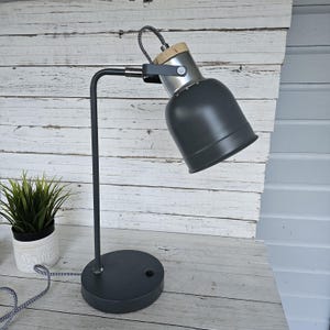 May include: A white ceramic mug with a black handle and the text "But First, Coffee" in a handwritten style. The mug is on a white surface. The mug is likely for hot beverages.