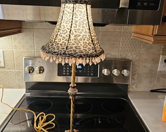 Tall Gold Colored Lamp with Leopard Skin material Trimmed in Beaded Tassels
