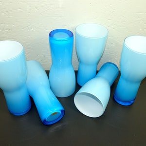 Könnte beinhalten: Sechs blaue und weiße Ombre-Glasbecher. Die Gläser sind alle in verschiedenen Formen und Größen. Einige sind hoch und dünn, während andere kurz und breit sind.