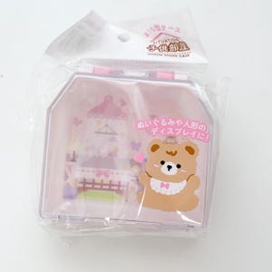 May include: A pink, house-shaped display case for dolls and plush toys. The case features a cartoon bear with a bib and the text "SITUATION CHILD'S ROOM HOUSE SHAPE CASE" in Japanese. The case is packaged in clear plastic.