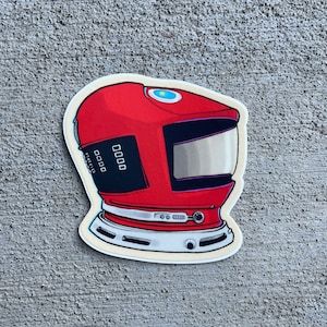May include: A red astronaut helmet sticker with a black visor and a white and blue design. The helmet has a digital display with the numbers 0000.