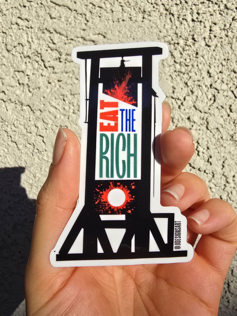 May include: Black and white sticker of a guillotine with red blood splatter. The sticker says "Eat the Rich" in green and white text. The sticker is on a white background and has the text "@JDESIGNISART" in the bottom right corner.