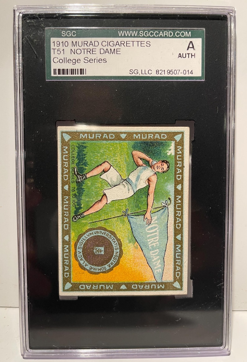 Puede incluir: Una tarjeta de intercambio vintage de cigarrillos Murad con un atleta de Notre Dame con un uniforme blanco lanzando una bala. La tarjeta est&aacute; bordeada en oro con el texto "MURAD" repetido alrededor de los bordes. La tarjeta est&aacute; calificada por SGC y autenticada.