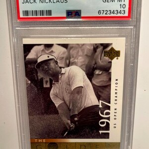 Puede incluir: Una tarjeta coleccionable de golf Upper Deck de 2001 con Jack Nicklaus. La tarjeta está calificada como GEM MT 10 y está dentro de un soporte protector. La imagen muestra a Nicklaus en acción, con texto que indica su Campeonato US Open de 1967.
