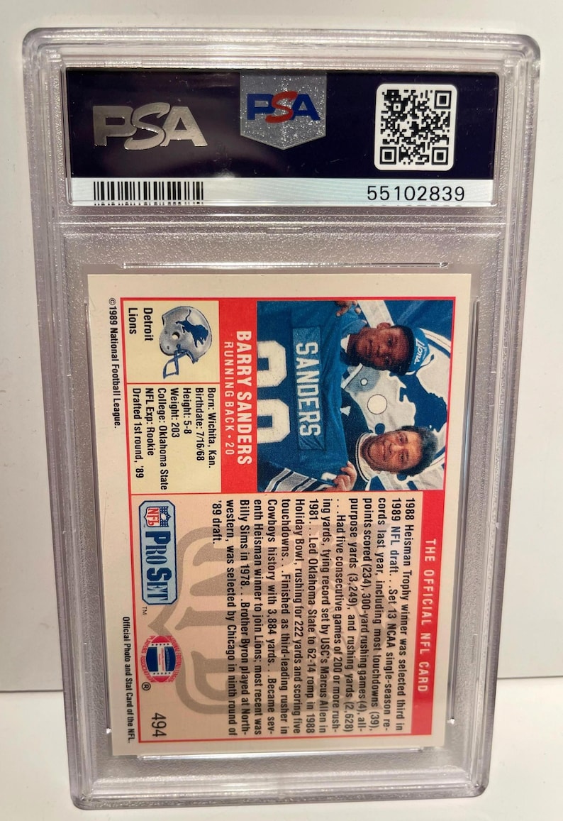 May include: A graded Barry Sanders football card from the 1989 Pro Set NFL series. The card features a photo of Sanders in a Detroit Lions uniform, with biographical information and statistics. The card is encased in a protective holder.