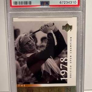 Puede incluir: Una tarjeta de golf Upper Deck de 2001 con Jack Nicklaus, calificada como GEM MT 10. La tarjeta muestra a Nicklaus en acción e incluye el texto "1978 British Open Champion". La tarjeta está dentro de un soporte protector.