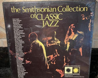 Op de afbeelding: Een vintage vinylalbum met de titel "The Smithsonian Collection of Classic Jazz". De albumhoes heeft een donkere achtergrond met de titel in grote gele letters en een lijst met jazzmuzikanten. De hoes bevat ook illustraties van jazzmuzikanten.
