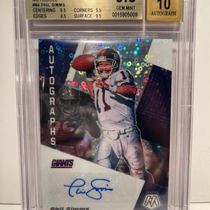 May include: A graded 2020 Panini Mosaic autograph card featuring Phil Simms of the New York Giants. The card is graded 9.5 by Beckett, with a 10 for the autograph. The card has a mosaic design and includes the player's signature.