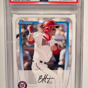 Könnte beinhalten: Eine Baseballkarte mit Bryce Harper, einem Baseballspieler der Washington Nationals. Die Karte stammt aus der Serie Bowman Prospects 2011 und ist mit #BP1 nummeriert. Die Karte ist in tadellosem Zustand und hat eine Note von 9.
