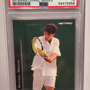 以下が含まれることがあります： 若いラファエル・ナダルがテニスをしている緑と白のトレーディングカード。カードはPSAによってGEM MT 10と評価されており、番号は77です。カードは2003年のNetproインターナショナルシリーズのものです。