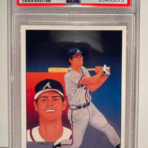 Puede incluir: Una tarjeta de béisbol de 1989 Upper Deck Dale Murphy Braves Checklist, calificada MINT 9 por PSA. La tarjeta presenta un retrato y una foto de acción del jugador. La tarjeta está dentro de un soporte protector.