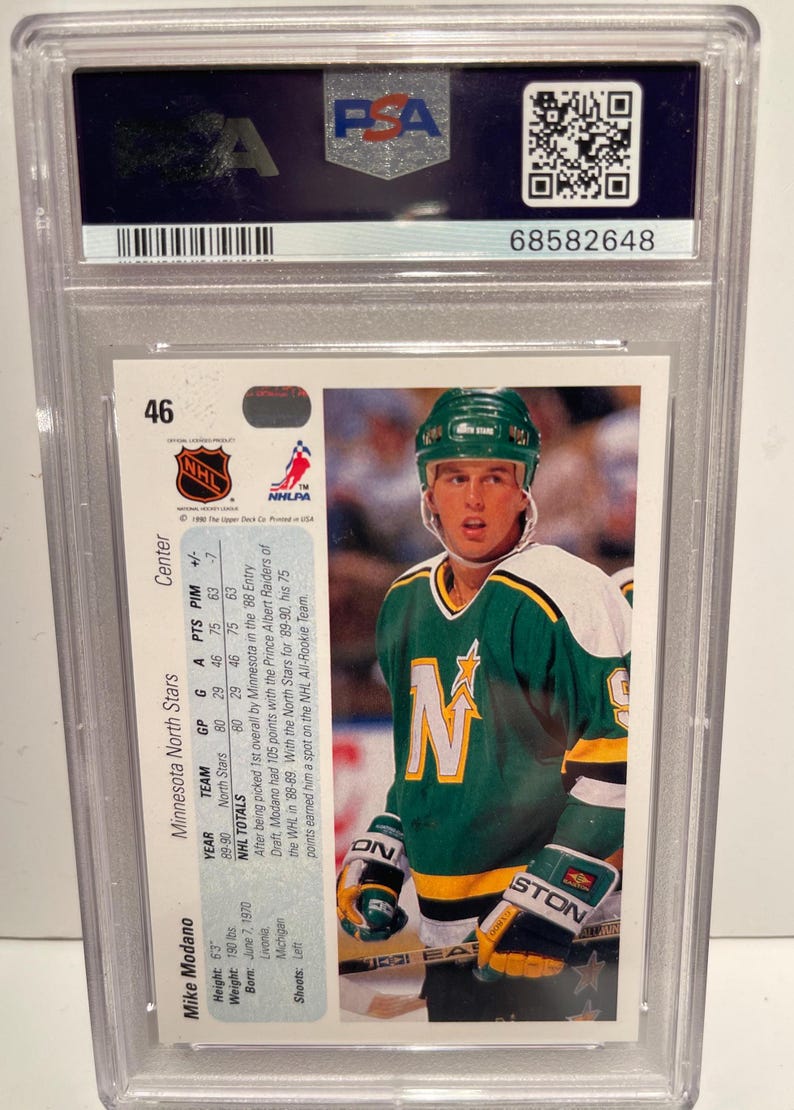 May include: A hockey card featuring Mike Modano, a center for the Minnesota North Stars. The card is from the 1989-90 Upper Deck series and features a photo of Modano in his North Stars uniform. The card also includes Modano's statistics for the 1989-90 season.
