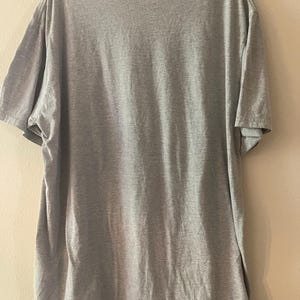 以下が含まれることがあります： クルーネックのグレーの半袖Tシャツです。