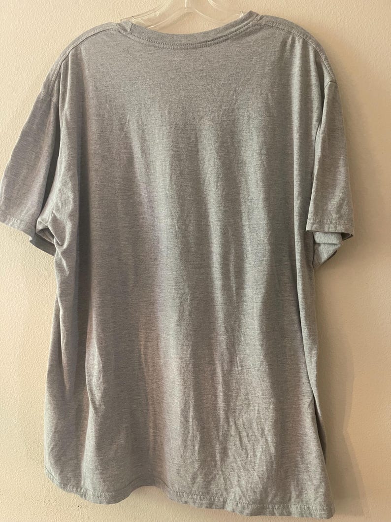 以下が含まれることがあります： クルーネックのグレーの半袖Tシャツです。
