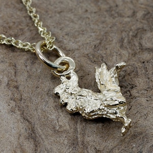 May include: A gold-tone rooster charm necklace. The rooster is detailed and has a textured finish. The chain is a delicate, thin chain.
